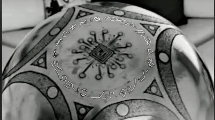 Close-up of the Buga Sphere surface showing engraved symbols, geometric patterns and central motif