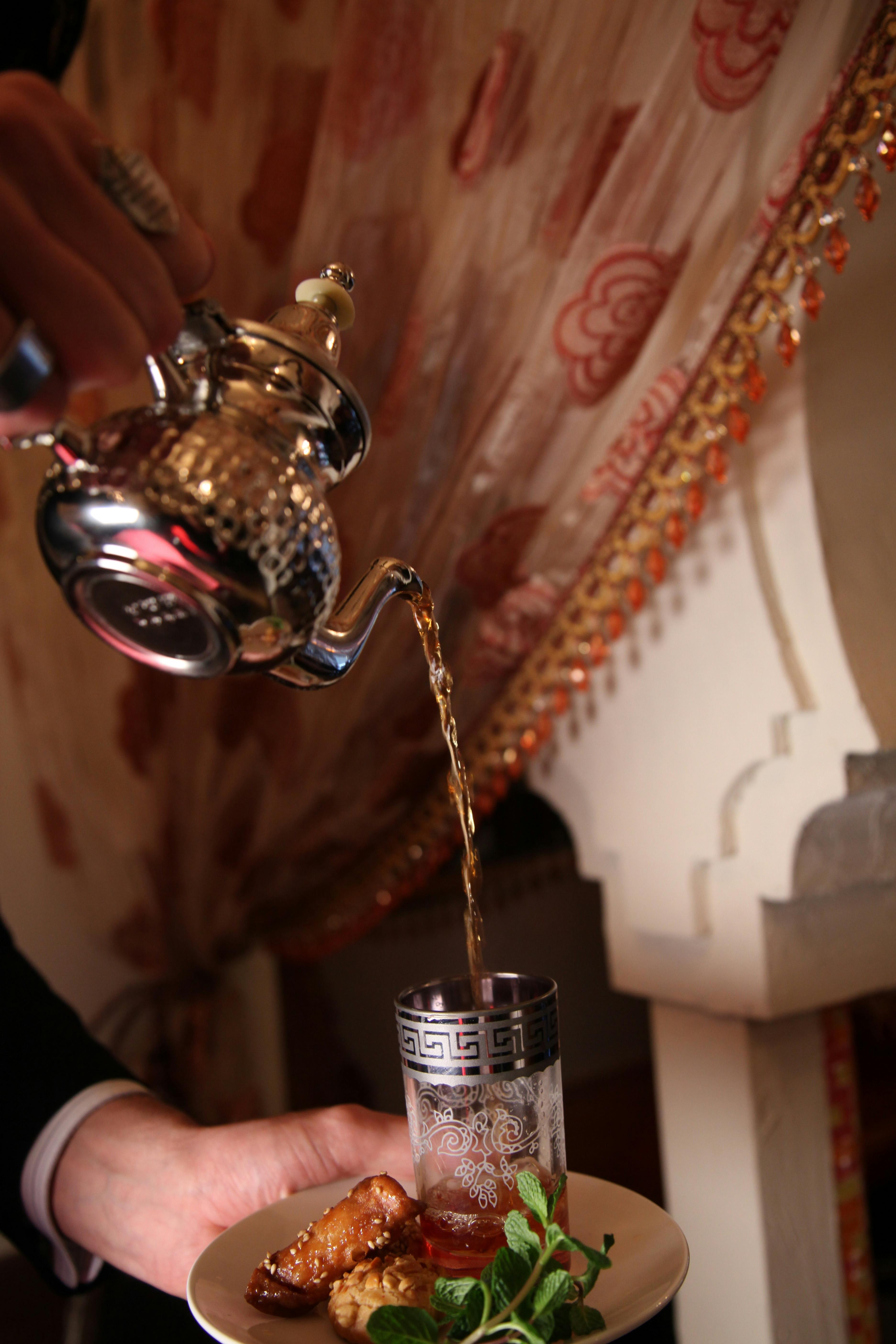 Moroccan mint tea being poured from height — the traditional atay ceremony